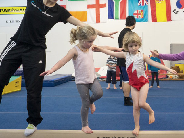 Preschoolers and coach on low beam